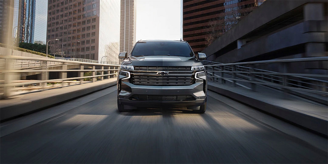 Chevrolet Tahoe 2021 gris vu de face en conduite urbaine sur une rampe entourée de gratte-ciel.