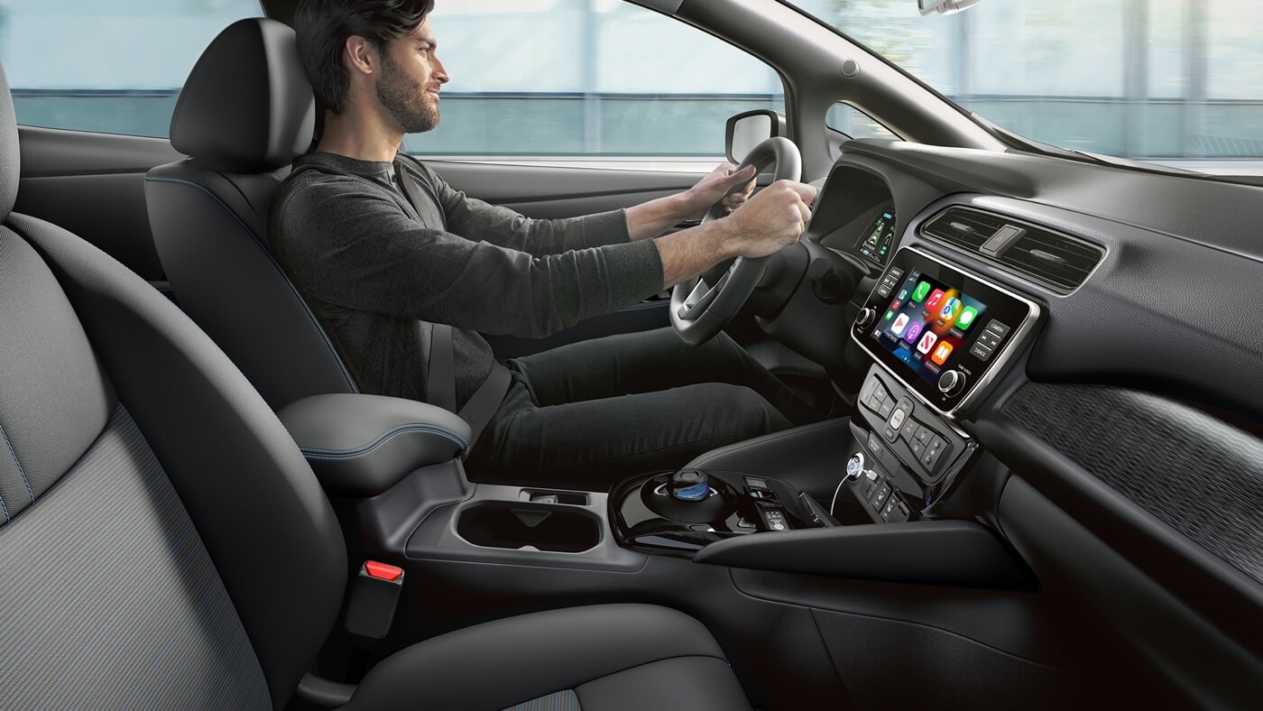 Homme au volant de la Nissan Leaf 2025.