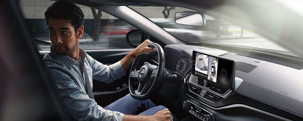 Homme au volant de la Nissan Altima 2025 utilisant les fonctionnalités du bouclier de sécurité 360.